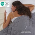 Mujer durmiendo bajo la manta lastrada Blumtal de algodón