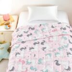 Manta pesada infantil Sleepymoon de unicornios sobre una cama